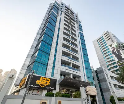 a tall building with a sign in front of it at Cozy Chic Studio l Next to Marina Mall in Dubai