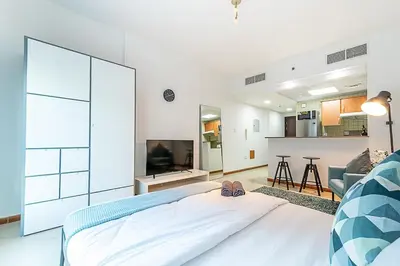 a bedroom with a bed and a living room at Cozy Chic Studio l Next to Marina Mall in Dubai
