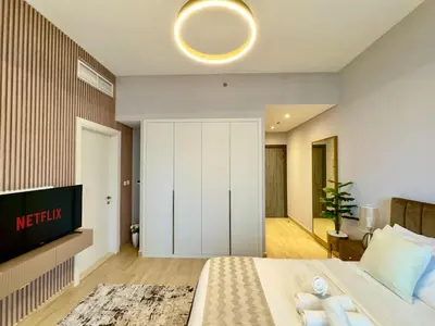 a bedroom with a bed and a tv on a wall at Brand New-Fully Furnished Classy Studio In JVC in Dubai