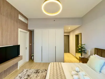 a bedroom with a bed with a tv and a sliding door at Brand New-Fully Furnished Classy Studio In JVC in Dubai