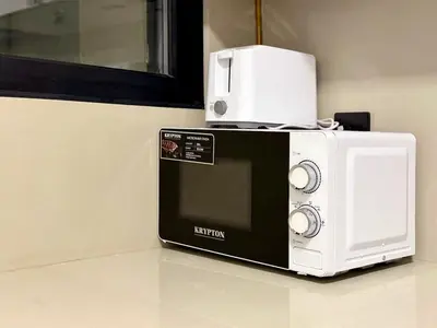 a microwave sitting on top of a kitchen counter at Brand New-Fully Furnished Elegant 1BR In JVC in Dubai