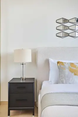 a bedroom with a bed and a table with a lamp at Frank Porter - Binghatti Corner in Dubai