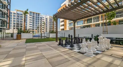 a chess game on a chess board in a courtyard at Frank Porter - Azizi Riviera 15 in Dubai
