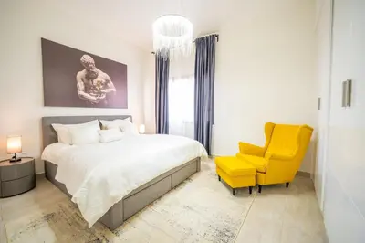 a bedroom with a bed and a yellow chair at 1BHK Luxury Serviced Apartment - Al Andalus JGE in Dubai