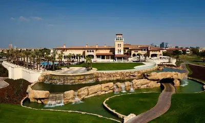 a building with a water fountain in a park at 1BHK Luxury Serviced Apartment - Al Andalus JGE in Dubai