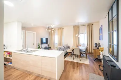 a kitchen and living room with a large white island at 1BHK Luxury Serviced Apartment - Al Andalus JGE in Dubai