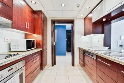 a kitchen with wooden cabinets and a microwave at Vibrant 1BR APT with Burj Khalifa View in Dubai
