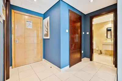 a hallway with blue walls and wooden doors at Vibrant 1BR APT with Burj Khalifa View in Dubai