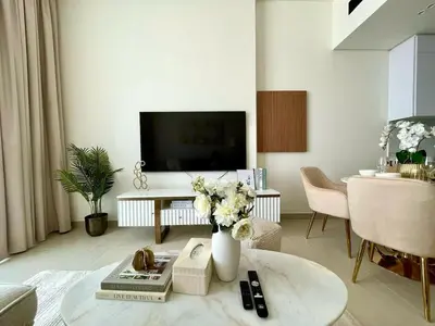 a living room with a vase of flowers on a table at Elegant Jvc 1br Balcony, Pool Access, Parking in Dubai