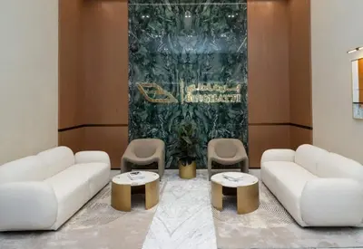 a living room with two white couches and two tables and chairs at Elegant Jvc 1br Balcony, Pool Access, Parking in Dubai