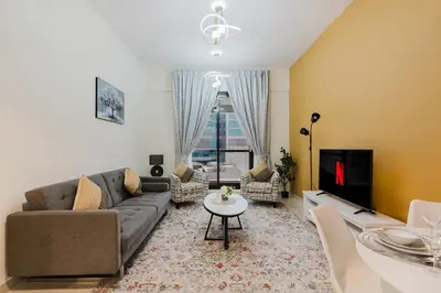 a living room with a couch and a tv at RH- Heart of Dubai Marina, Sunny & bright 2 BR apartment with big balcony in Dubai