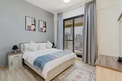 a bedroom with a bed and a large window at RH- Heart of Dubai Marina, Sunny & bright 2 BR apartment with big balcony in Dubai