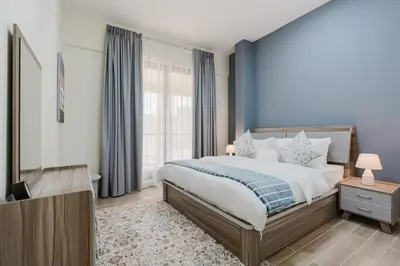 a bedroom with a bed with a blue wall at RH- Heart of Dubai Marina, Sunny & bright 2 BR apartment with big balcony in Dubai