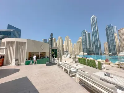 a group of benches on a boardwalk with a city at AWS Holiday Homes - Views from the Sky in Dubai