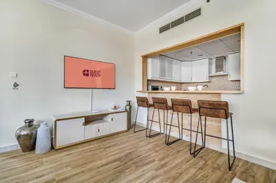 a kitchen with a counter and stools in a room at GuestReady - Contemporary living in Dubai Marina in Dubai