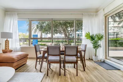a living room with a table and chairs and a large window at GuestReady - Contemporary living in Dubai Marina in Dubai
