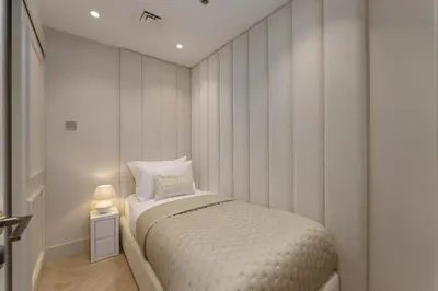 a small bedroom with a bed and a side table at Daniels 4BR At Princess Tower with Marina and Sea view in Dubai