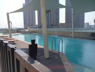 a swimming pool with an umbrella on top of a building at Stylish 2BR Apartment by Missoni near Dubai Mall in Dubai