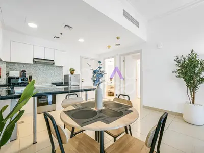 a kitchen and dining room with a table and chairs at Modern 1BR Oasis II Huge Layout II City Lights in Dubai