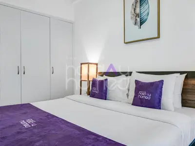 a bedroom with a large bed with purple pillows at Modern 1BR Oasis II Huge Layout II City Lights in Dubai