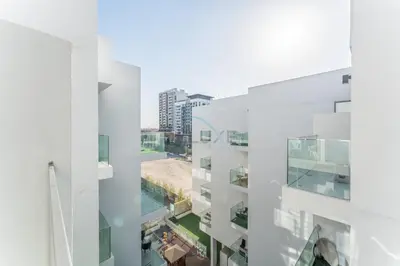 a view from the balcony of a building at Balcony Offering Community Views 1BR with Assistant Room, Walking Distance to Community Park , Pantheon Elysee , Jumeirah Village Circle by Deluxe Holiday Homes in Dubai