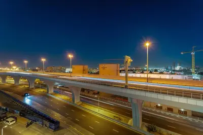a bridge over a highway at night with street lights at FIRST CLASS 1BR Elegant Marina Hideaway in Dubai