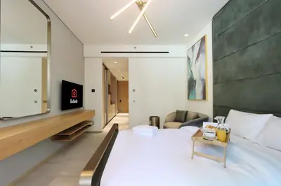 a bedroom with a large bed with a tv on the wall at Livbnb - Serene Studio with Private Terrace in JVC in Dubai