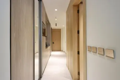 a hallway with white walls and white floors and a hallway with wooden doors at Livbnb - Serene Studio with Private Terrace in JVC in Dubai