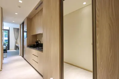 a kitchen with wooden cabinets and a glass wall at Livbnb - Serene Studio with Private Terrace in JVC in Dubai