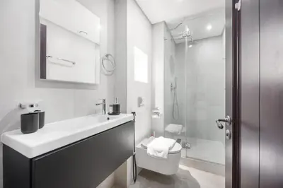 a bathroom with a sink and a toilet and a shower at AirDXB - Luxurious 2-Bedroom Apartment in Downtown - Sleeps 4 with Iconic Burj Khalifa Views in Dubai