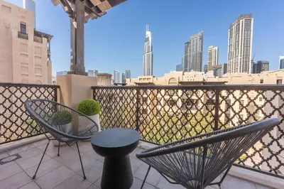 a balcony with chairs and a table and a view of the city at AirDXB - Luxurious 2-Bedroom Apartment in Downtown - Sleeps 4 with Iconic Burj Khalifa Views in Dubai