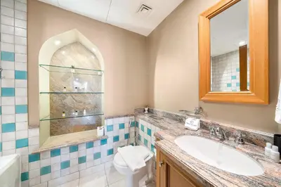 a bathroom with a sink and a mirror and a toilet at Charming Old Town Dubai 2BR Retreat with Burj Khalifa Balcony View in Dubai