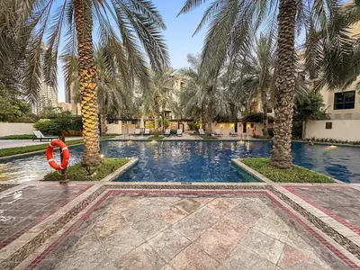a swimming pool with palm trees and a life preserver at Charming Old Town Dubai 2BR Retreat with Burj Khalifa Balcony View in Dubai