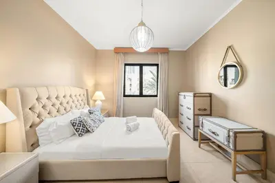 a bedroom with a large white bed and a mirror at Charming Old Town Dubai 2BR Retreat with Burj Khalifa Balcony View in Dubai