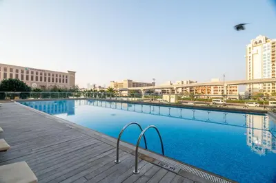 a large swimming pool in a city with buildings at GuestReady - West Side Studios in Palm Jumeirah in Dubai