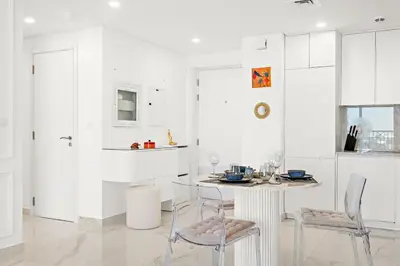 a white kitchen with a table and chairs at Premium 1BR with Iconic Skyline Views with Balcony & Pool in Dubai