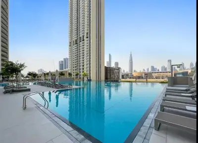 a large swimming pool in a city with buildings at Vogue Downtown Views II with Direct Access to Dubai Mall Via a Climate Controlled Bridge, Two Bedroom Apartment with Balcony and Burj Khalifa View in Dubai