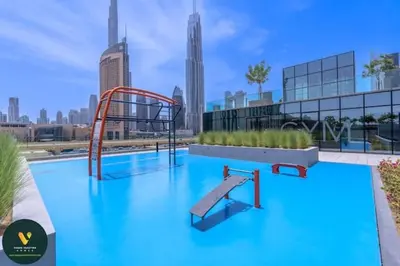 a pool with a slide in the middle of a city at Vogue Downtown Views II with Direct Access to Dubai Mall Via a Climate Controlled Bridge, Two Bedroom Apartment with Balcony and Burj Khalifa View in Dubai