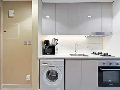 a kitchen with a washing machine and a sink at Prime Studio Apt at Azizi Riviera 45, Meydan in Dubai