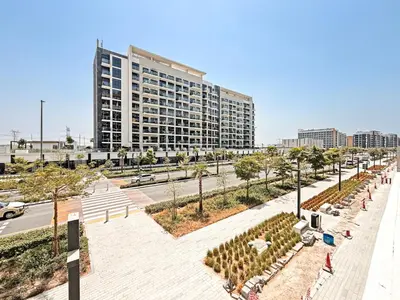 a city street with a large building in the background at Prime Studio Apt at Azizi Riviera 45, Meydan in Dubai