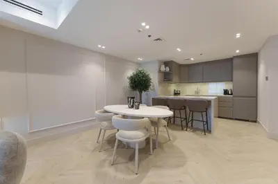 a kitchen with a white table and chairs and a counter at Daniels 2BR at Princess Tower with Sea View in Dubai
