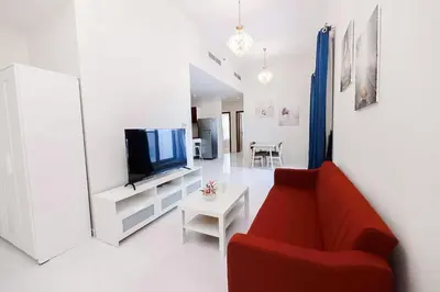 a living room with a red couch and a tv at MK Residence JVC in Dubai