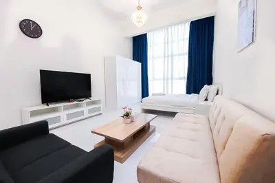 a living room with a couch and a tv at MK Residence JVC in Dubai
