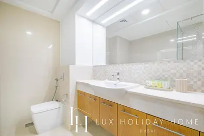 a bathroom with a sink and a toilet and a mirror at LUX The Executive Burj Khalifa View Suite 2 in Dubai