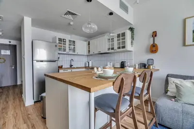 a kitchen with a table and a kitchen with a refrigerator at GuestReady - Modern urban retreat in JLT in Dubai