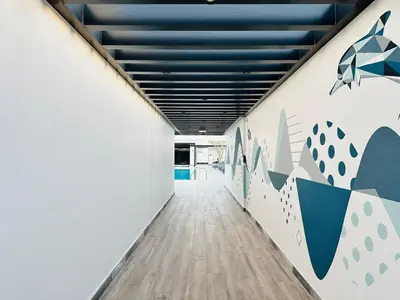 a corridor of an office with white walls and a blue ceiling at Peaceful 2 Bed Oasis Suite in JVC in Dubai
