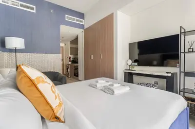 a bedroom with a large white bed and a desk at Stunning Luxury Studio in Dubai in Dubai