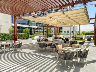 a patio with tables and chairs in a building at Stunning Luxury Studio in Dubai in Dubai