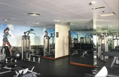 a gym with a mural of a woman running on a treadmill at AWS Holiday Homes - Style in Downtown in Dubai