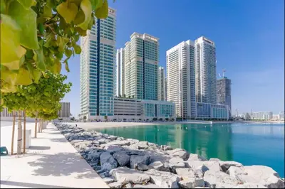 a city with tall buildings next to a body of water at AWS Holiday Homes - Amazing Beachfront Stay in Dubai